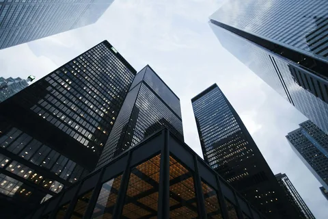 Office towers viewed from below, used as illustrative financial-district photography
