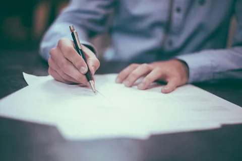 A person reviewing a paper document, used as illustrative photography